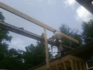 Carpenter setting a ridge beam over a new addition frame — Ice Dam Removal by Roofing Brothers in Cedartown