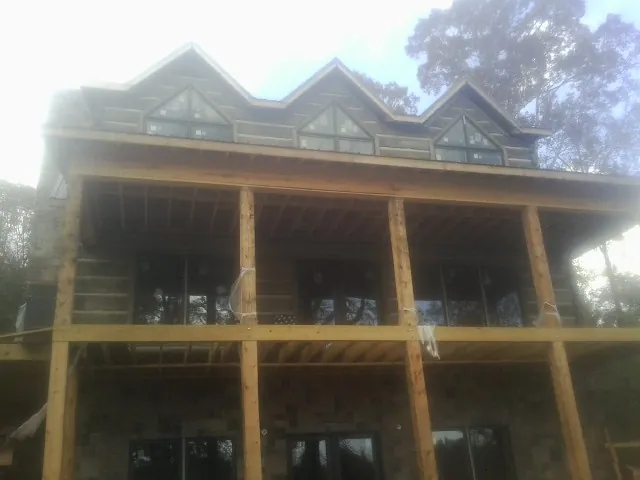 Dormers and porch framing on a large log home under construction — Roof Coating work by our crew in Cedartown