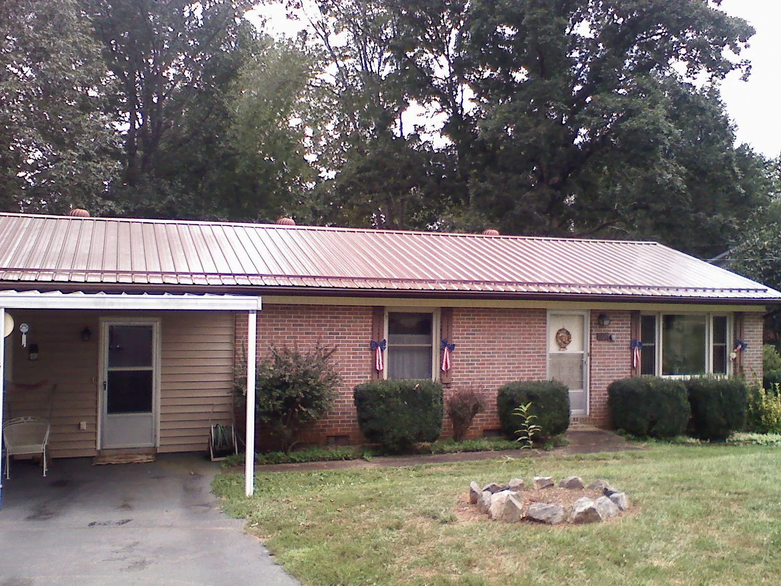 Bronze metal roof and carport on a brick ranch home — Roof Repair work by our crew in Cedartown